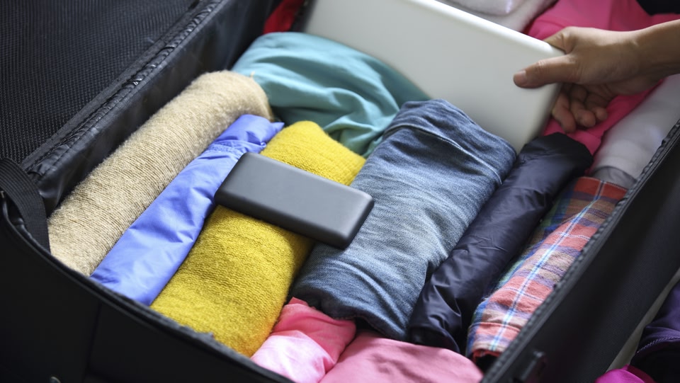 un bagaglio a mano aperto con vestiti piegati.