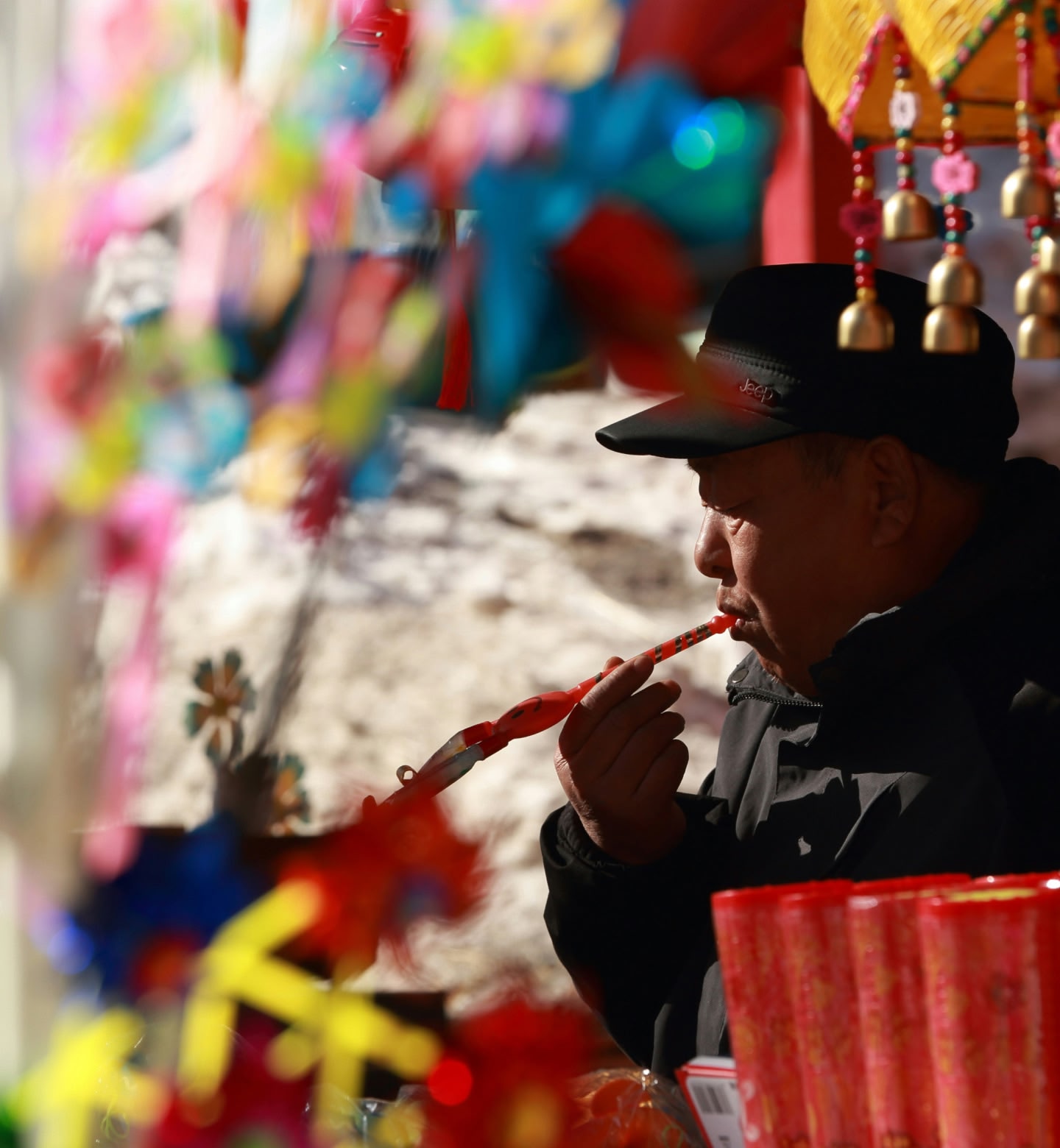 Seller sitting in colourful market stall in Urumqi China