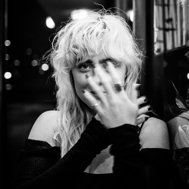 Singer Ny Oh with her hands covering part of her face