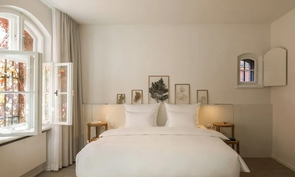 Una habitación en el hotel Wilmina de Berlín decorada con interiores blancos y detalles naturales.