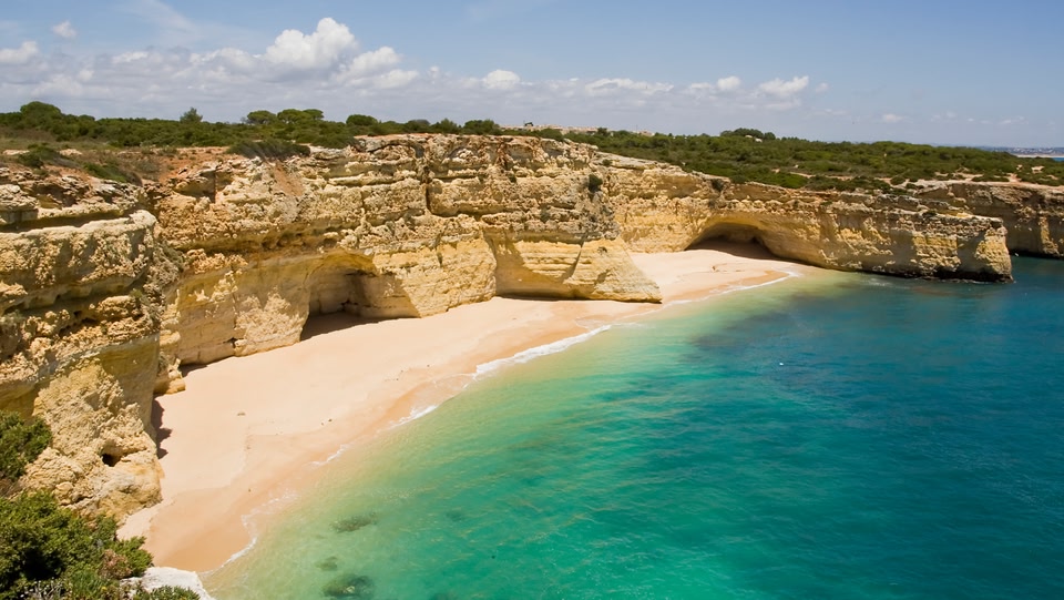 Coastal views of cliffs near a sandy beach and blue ocean