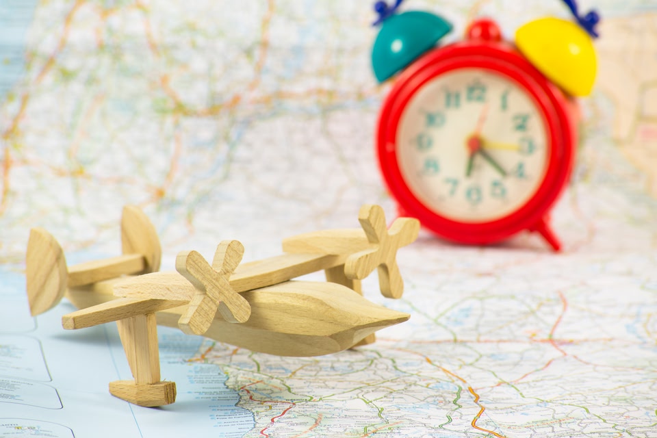 A wooden toy plane and a colourful clock on a map