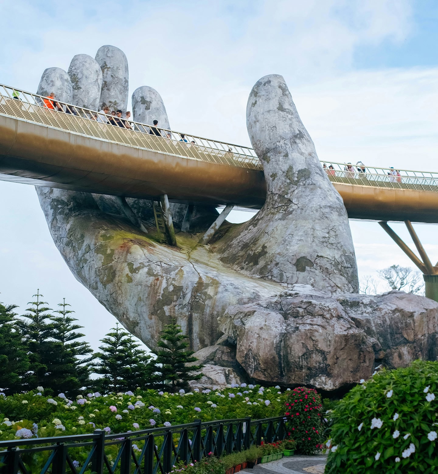 A view of the Golden Bridge in Da Nang, Vietnam - a pedestrian bridge held up by giant stone hands.