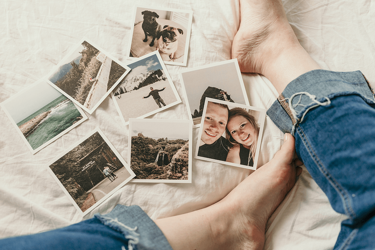 Polaroid pictures from a previous holiday spread out on the bed.