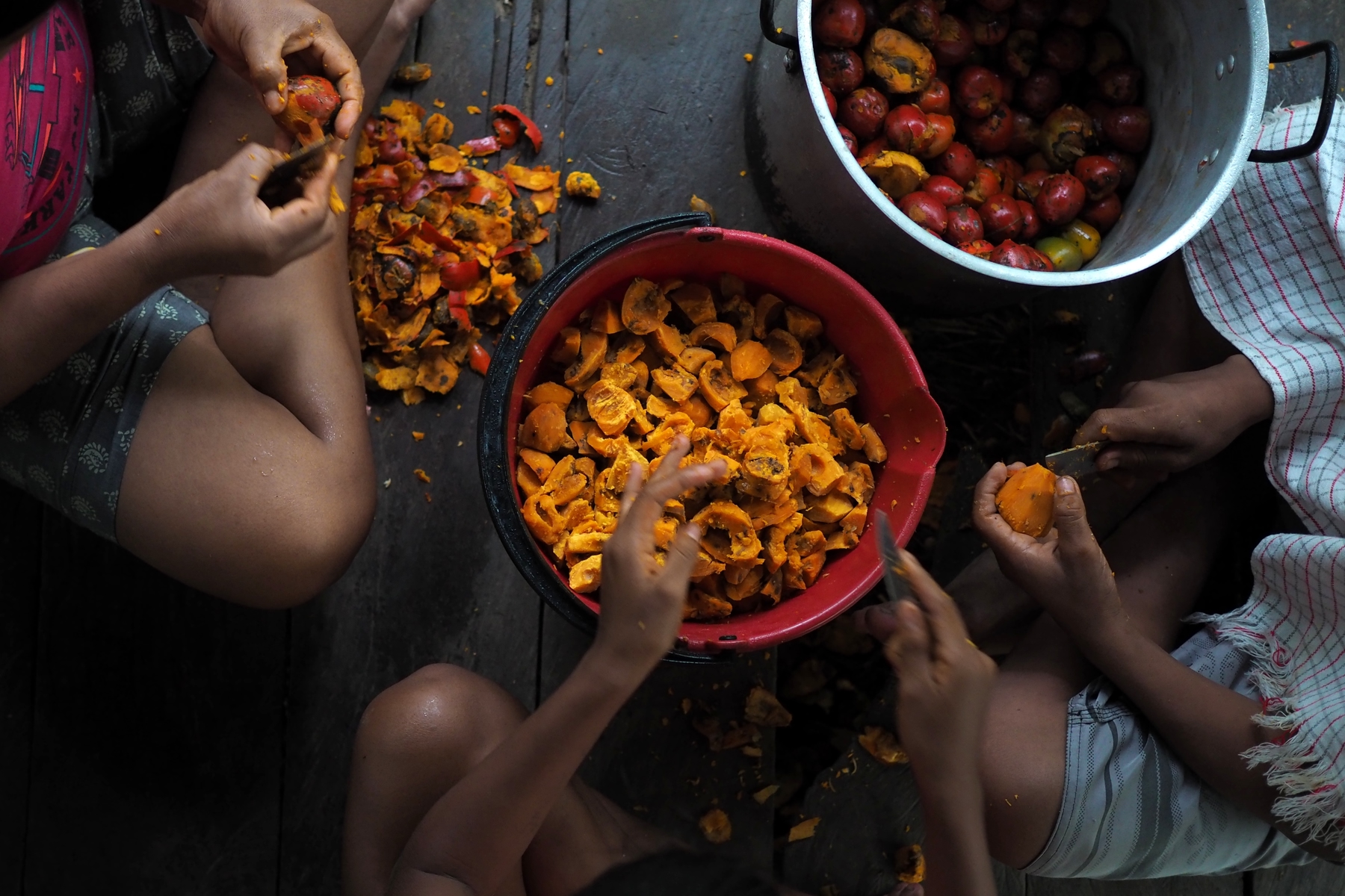 people sitting down peeling veggies
