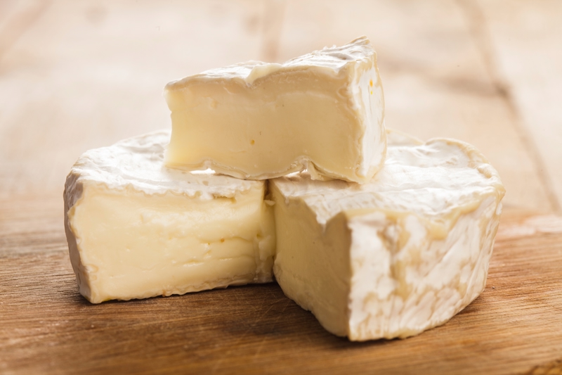 camembert cheese being cut