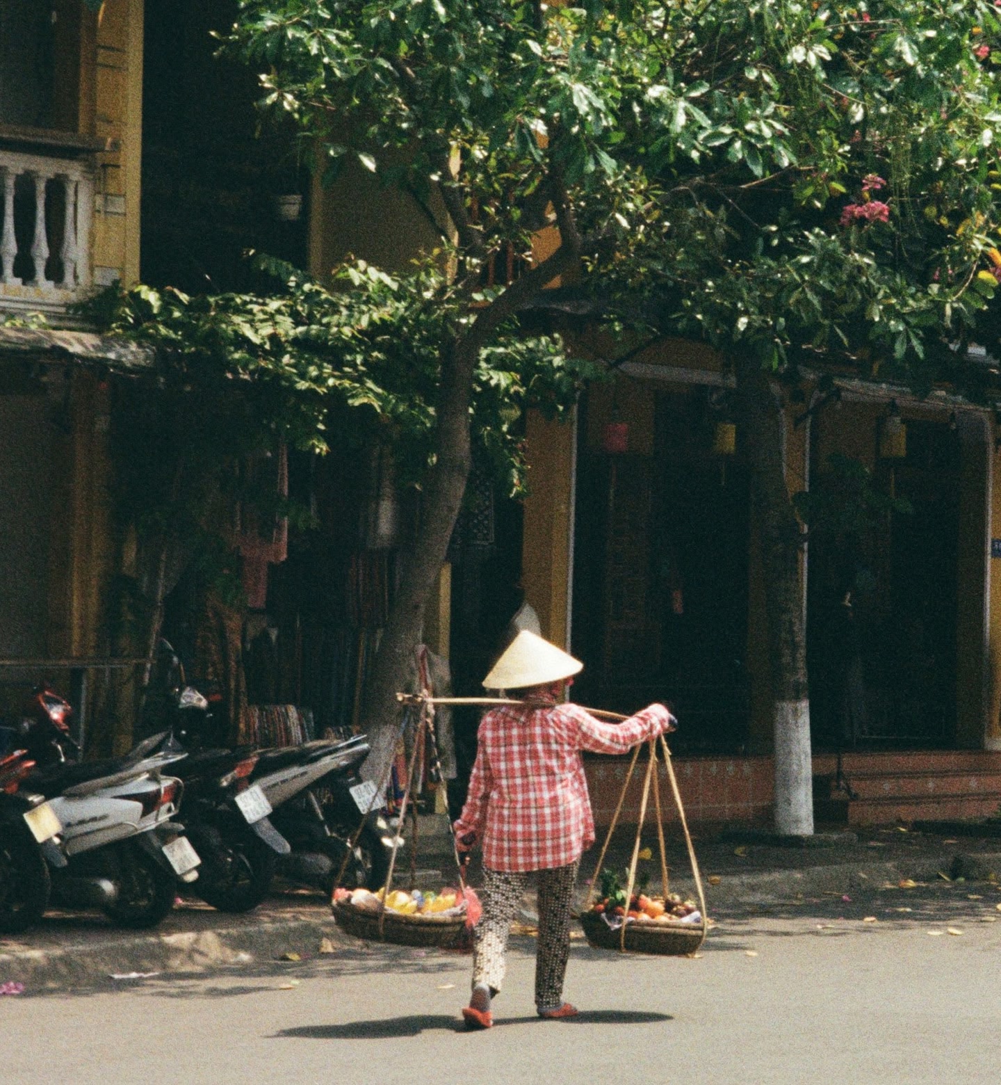Local wearing a traditional hat carrying fruit in Phu Quoc, Vietnam