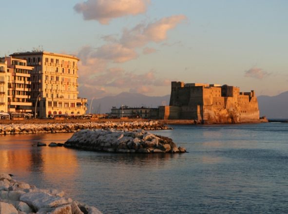 An image of an old castle by the sea during sunset time