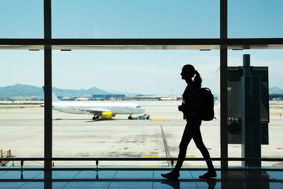 Γυναίκα περπατάει σε διάδρομο αεροδρομίου