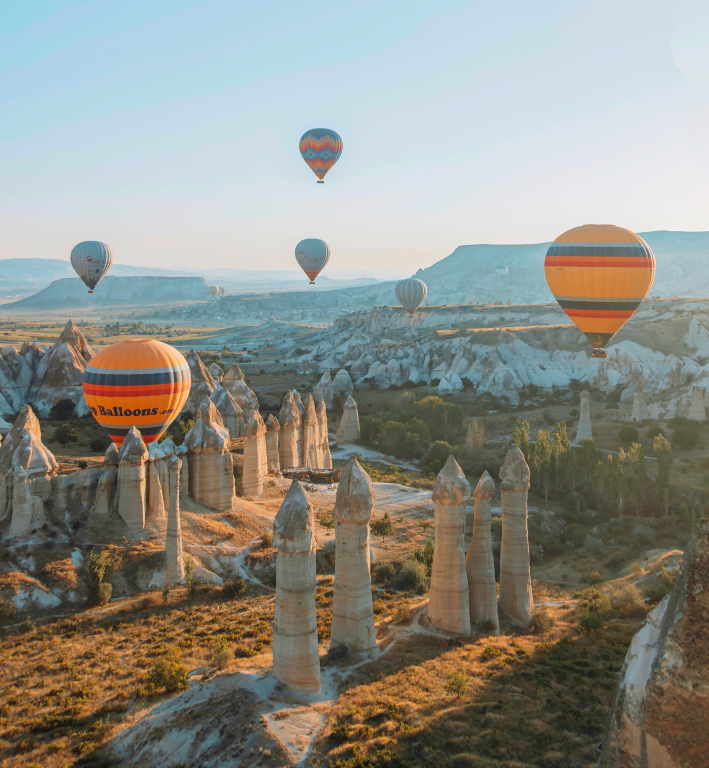トルコのネヴシェヒルの奇岩の上を飛ぶ、色鮮やかな熱気球。