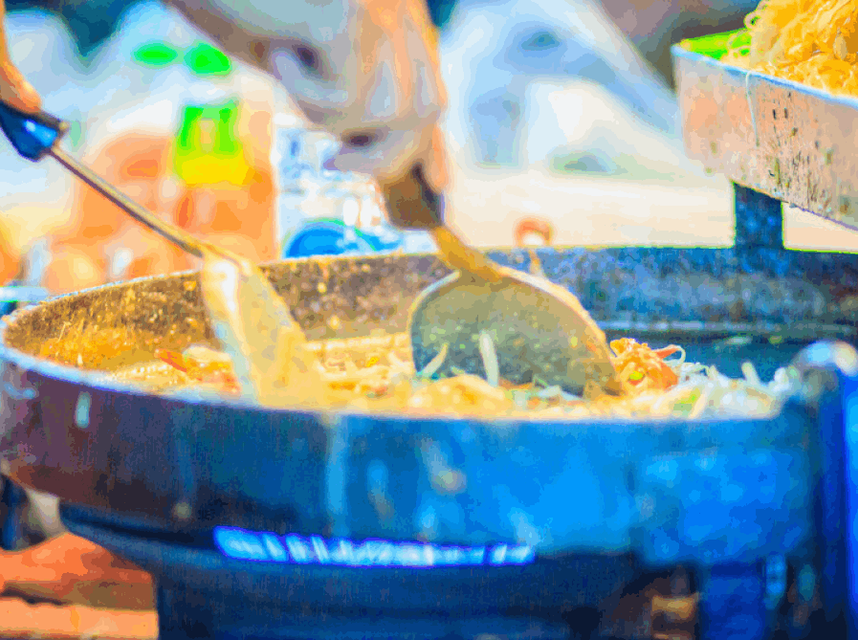 Close-up of a sizzling pan cooking authentic Thai street food.