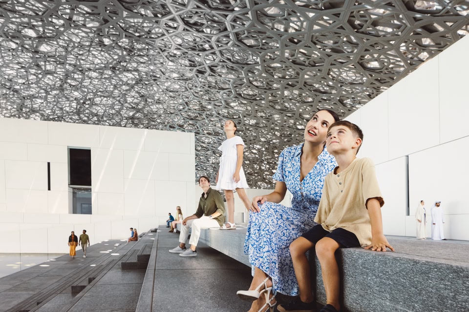 Une femme et un jeune garçon regardent le dôme du Louvre, à Abu Dhabi.