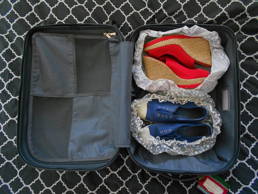 Shoes inside shower caps in a suitcase