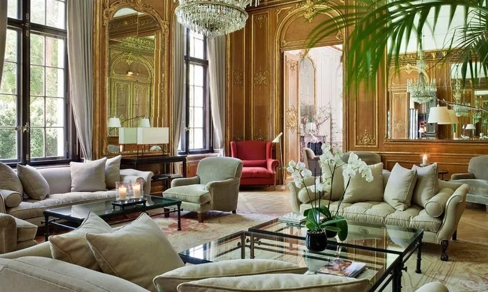 Una gran sala de estar en el Schlosshotel Berlin con elementos de diseño tradicional y grandes ventanales.