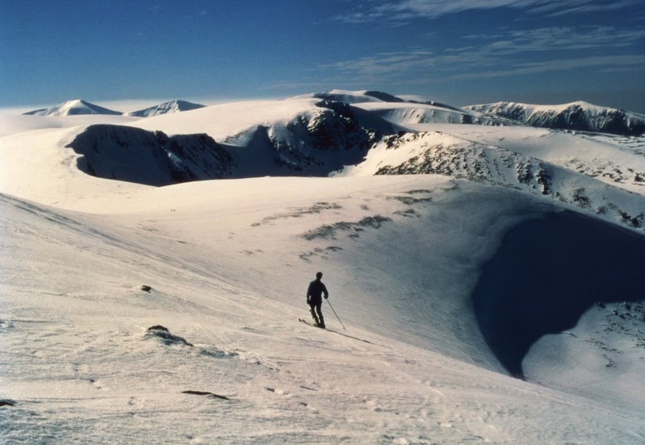 A person skiing down a ski slope in Cairngorm, Scotland.