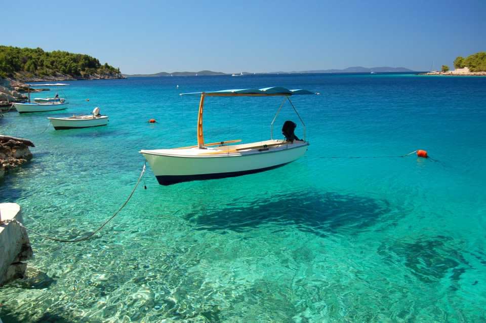boat docked over turquoise waters on Brac island in Croatia