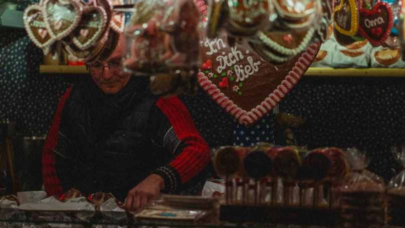 L'homme sur l'étal du marché de Noël vendant des cookies allemands