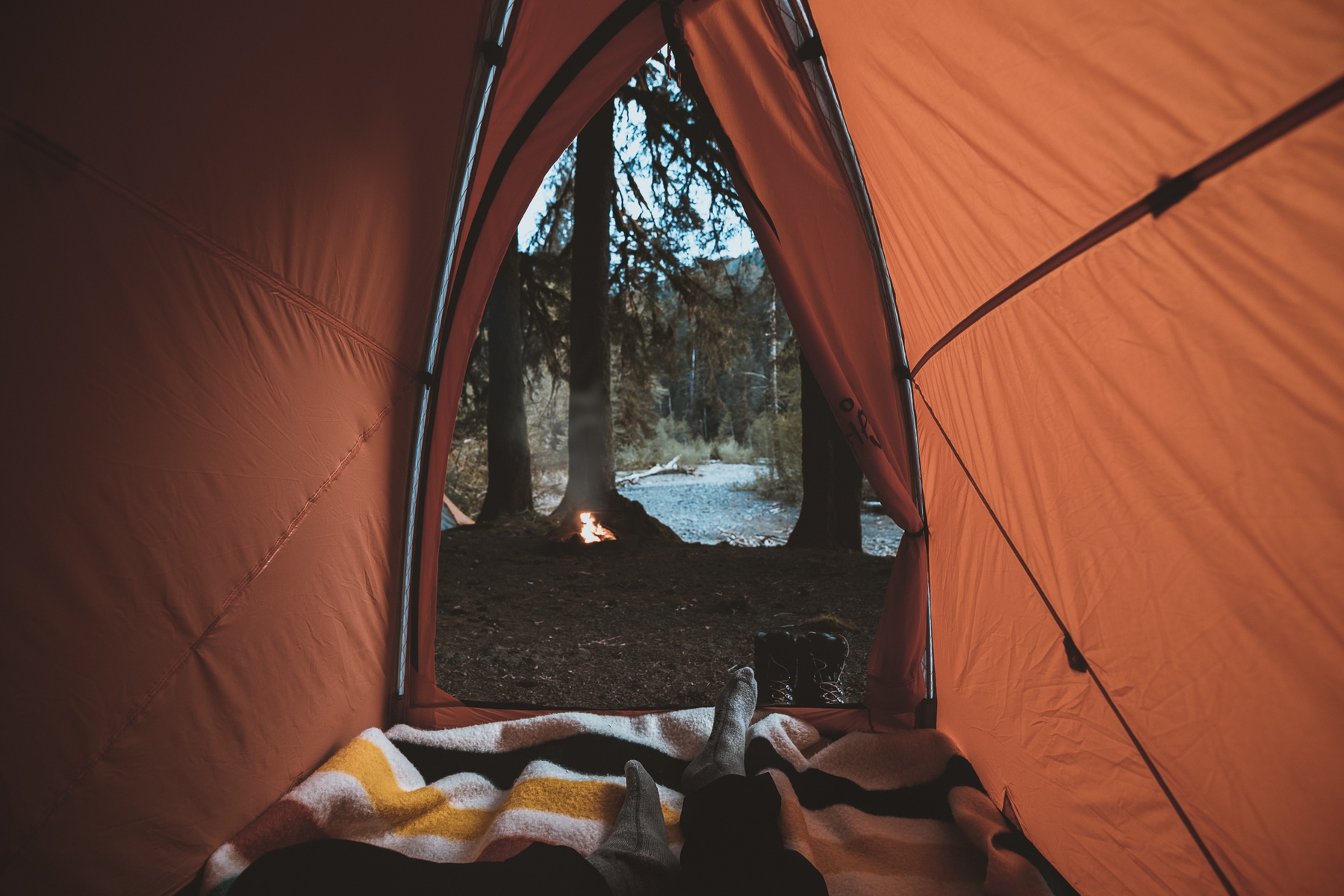 view from inside a camping tent to a lake