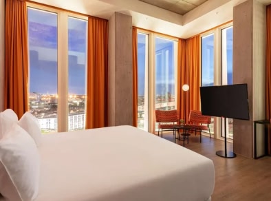 image d'une chambre d'hôtel avec lit et télévision avec vue sur la ville