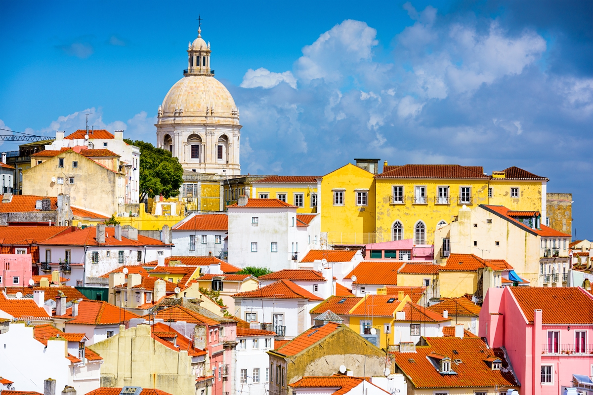A cluster of colourful buildings and a church in Lisbon, Portugal.