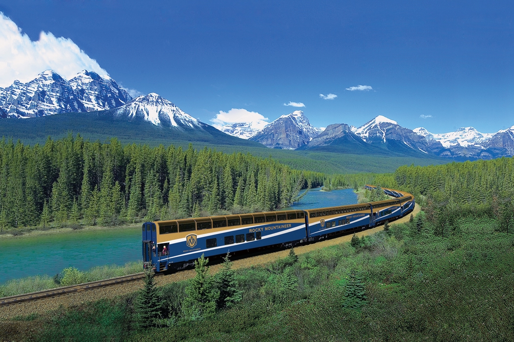 Το Rocky Mountaineer τρέχει πάνω στις ράγες με βόντο τα Καναδικά Βραχώδη Όρη.