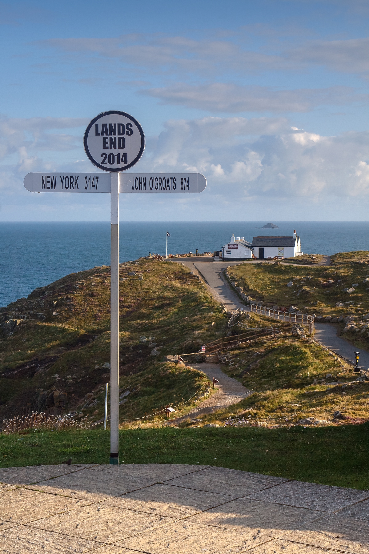 Signpost at Land's End, Cornwall, showing the distance to New York (3147 miles) and John O'Groats (874 miles).