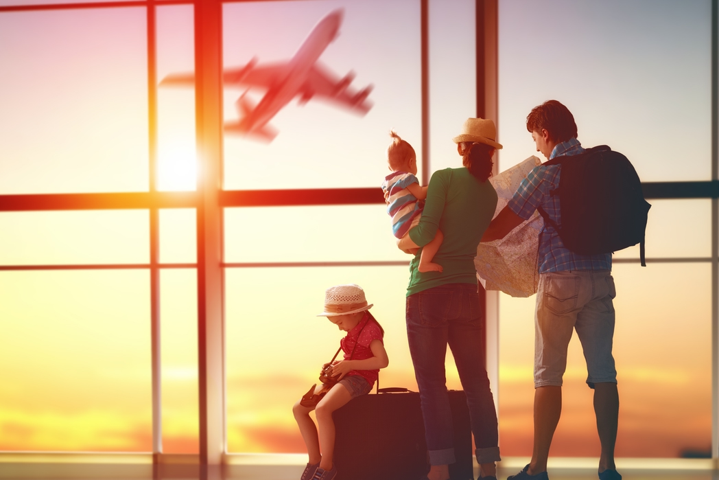 Family with suitcases at the airport - Avoid airline charges with these 10 insider tips