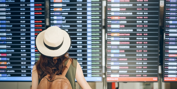 Asian tourists women  standing view flight schedules at the airport to prepare for boarding