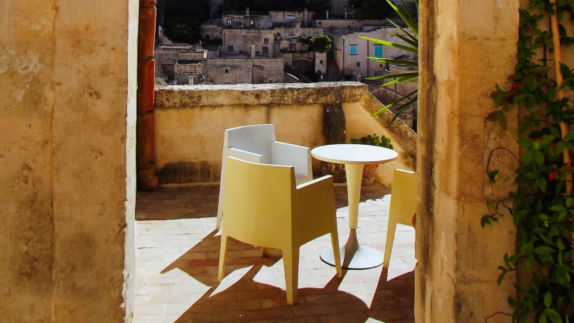  Balcone soleggiato con tavolo e sedie.