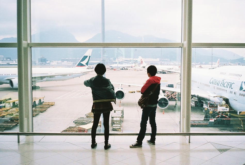 Duas pessoas olhando pela janela do aeroporto - Wifi aeroporto