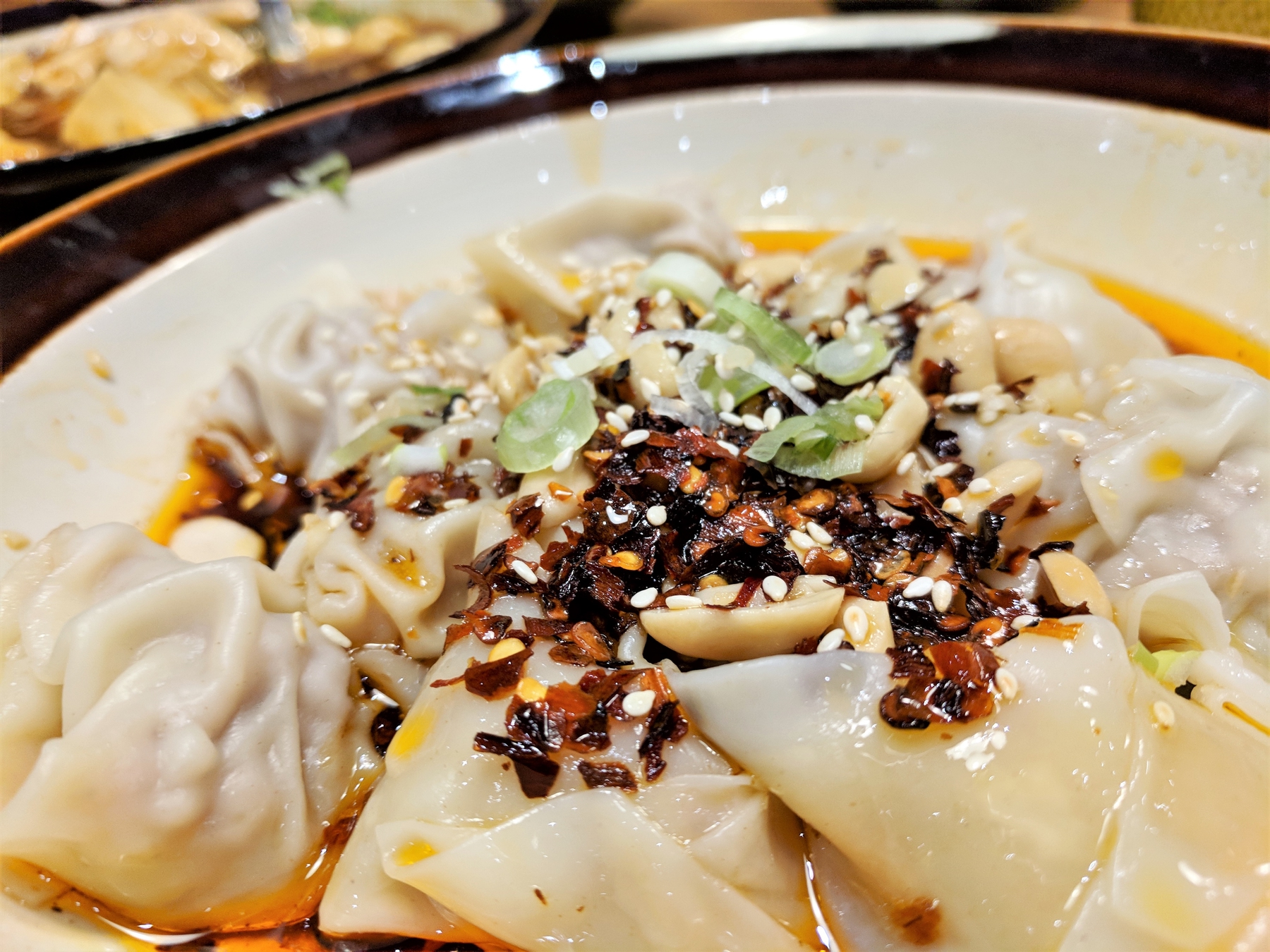 close up of a plate of dumplings with seasoning