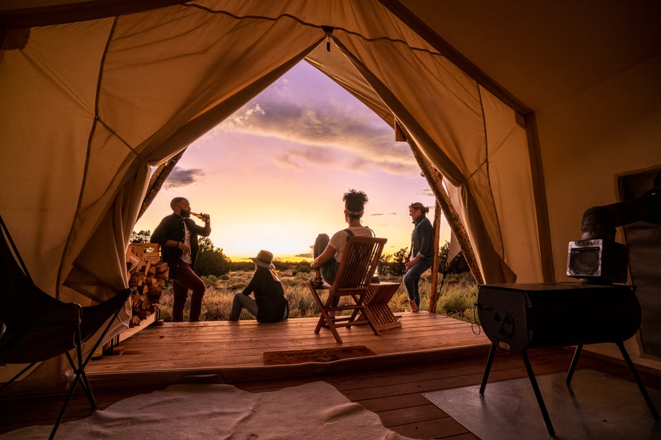 View of young people sitting outside a tent watching the sunset in Flagstaff, Arizona