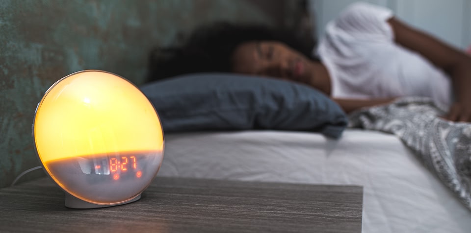 Woman asleep in bed with dim light on