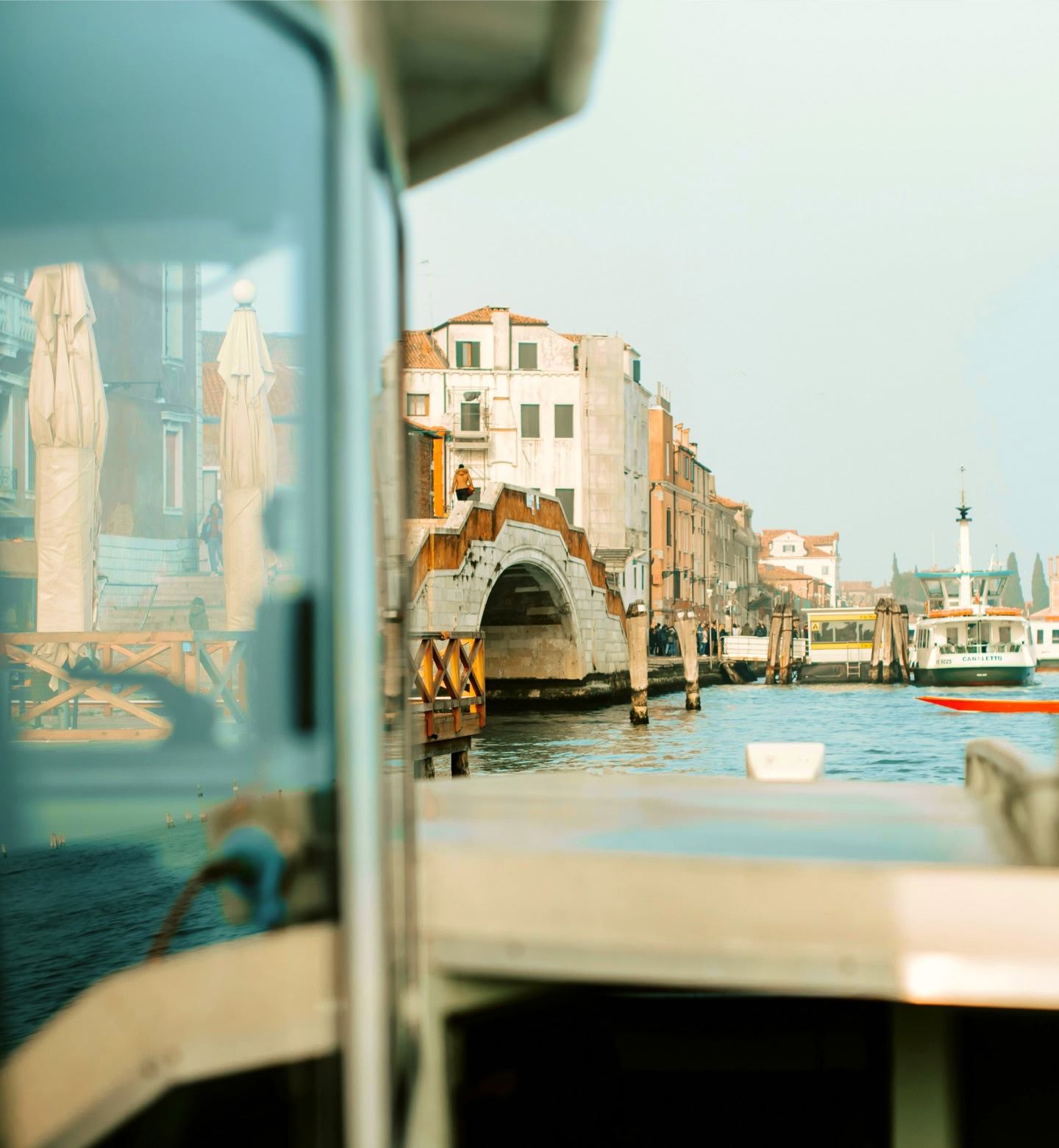 A boat cruises through past bridges and pastel buildings in Port Blair.
