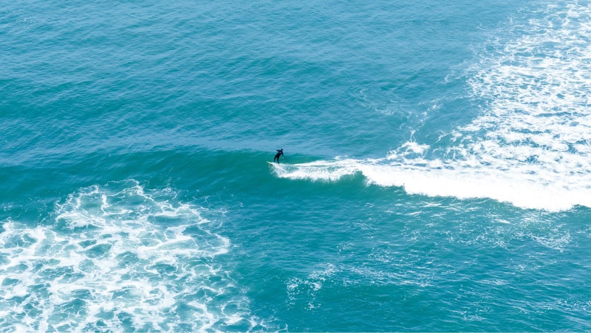 An image of a man surfing on the ocean during daytime