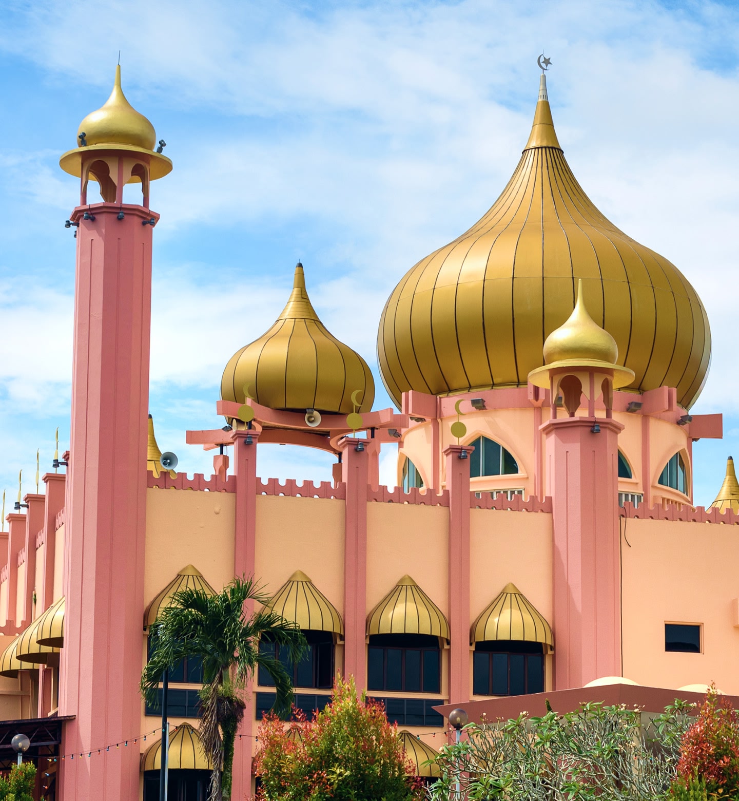 Bright mosque with gold domes and pink minarets in Kuching, Malaysia.