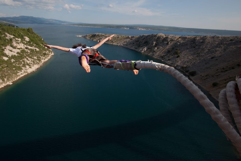 Una persona haciendo puenting sobre el agua en Queenstown.
