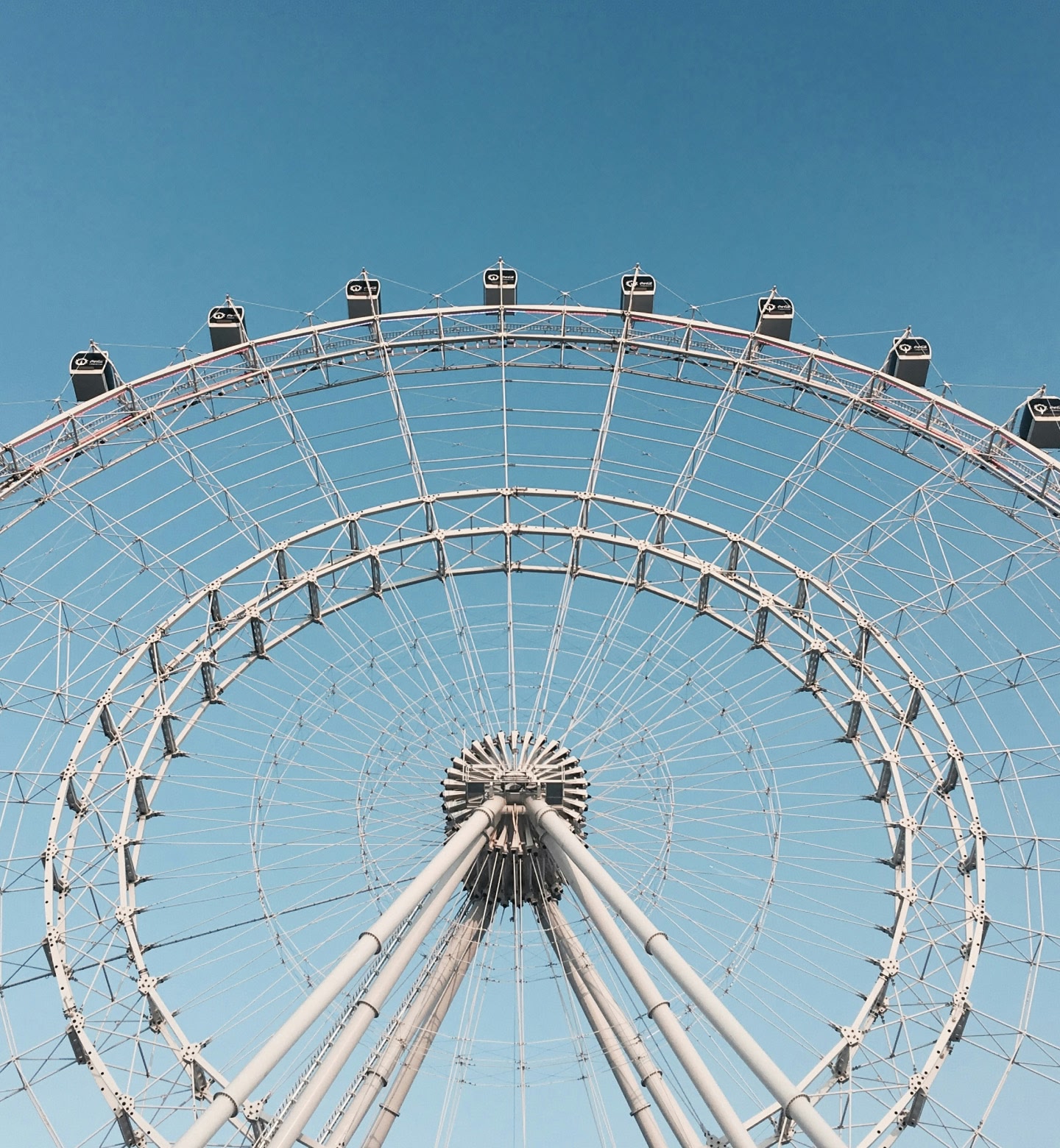 Close de uma roda-gigante branca em frente a um céu azul claro em Orlando, Estados Unidos.