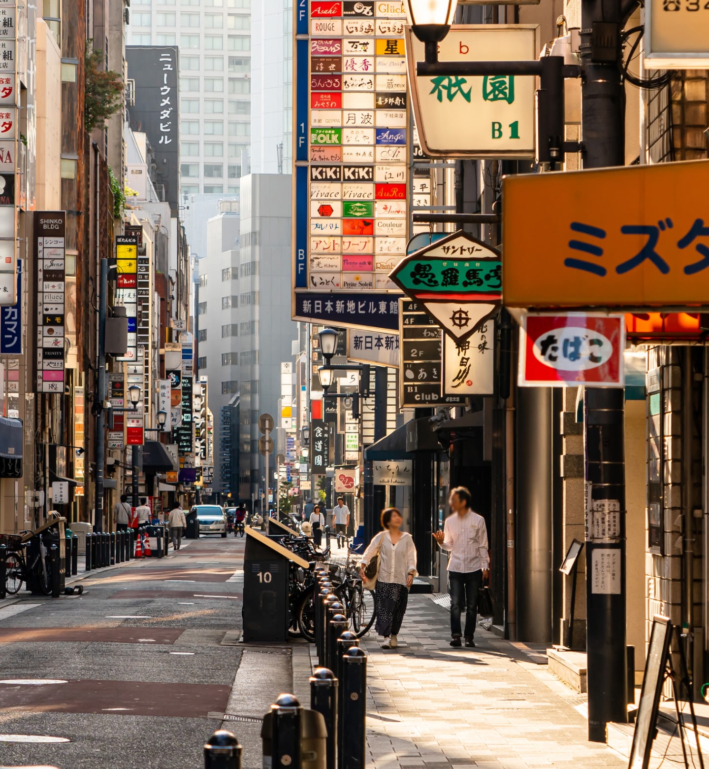 Couple walk down city street in Osaka Japan