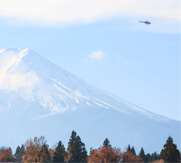 A helicopter flying past Mount Fuji.