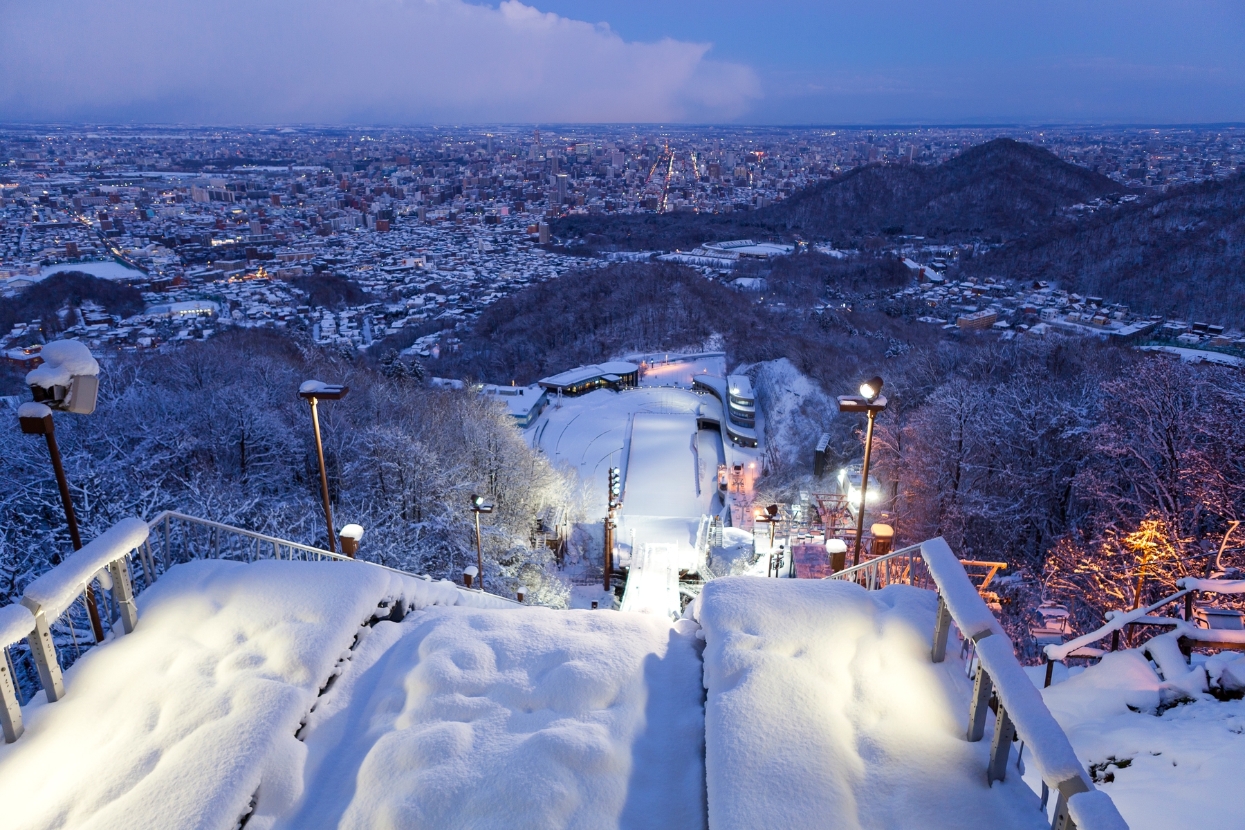 Looking down from the top of a ski jump to the lights of Sapporo city in Hokkaido, Japan.