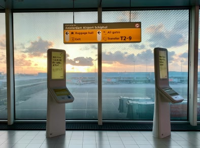 Une photo du hall de l'aéroport d'Amsterdam avec des kiosques