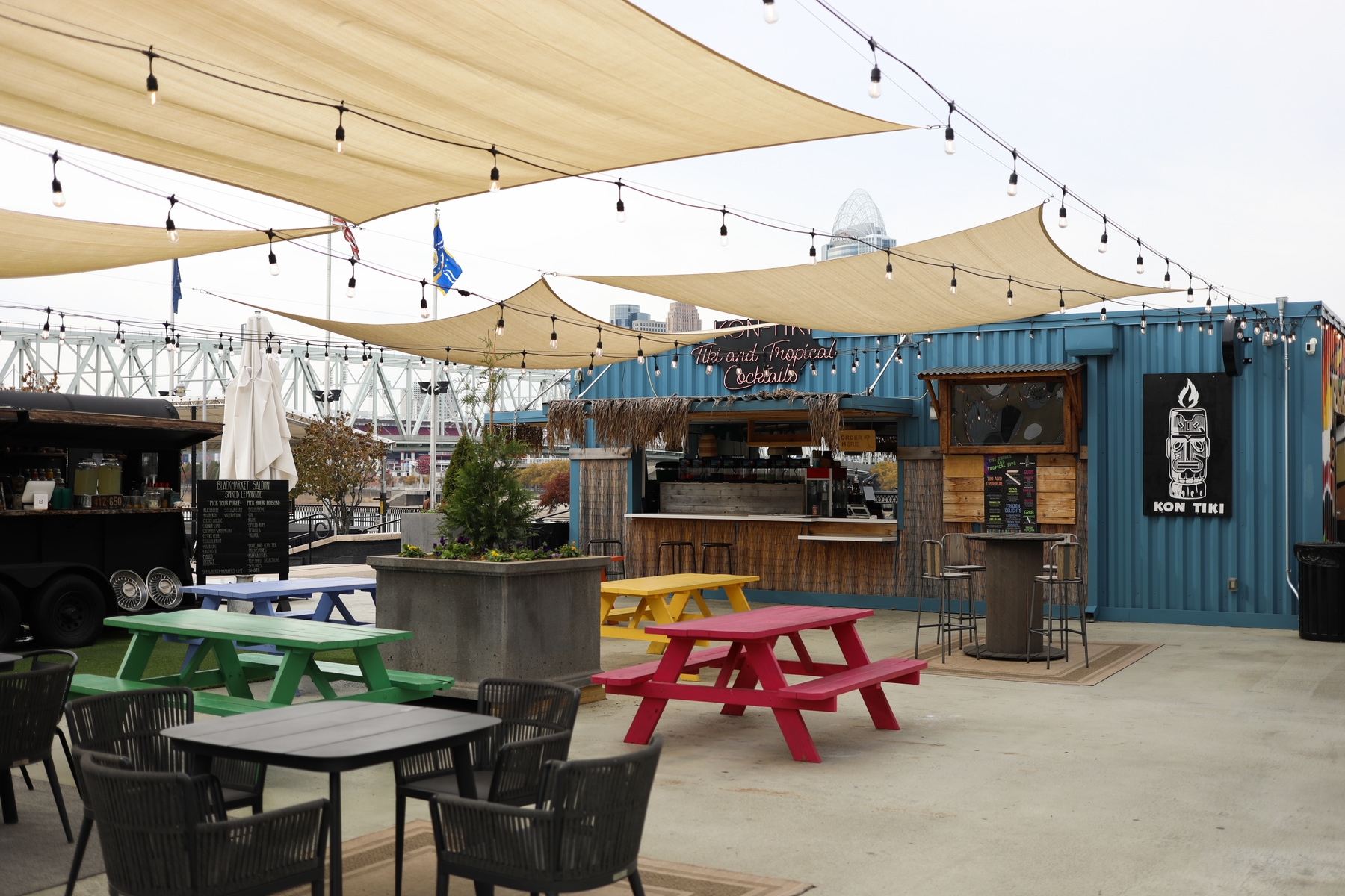 Kon Tiki bar at Newport Levee. Colourful picnic tables underneath an awning, beside a bar set inside a shipping container.