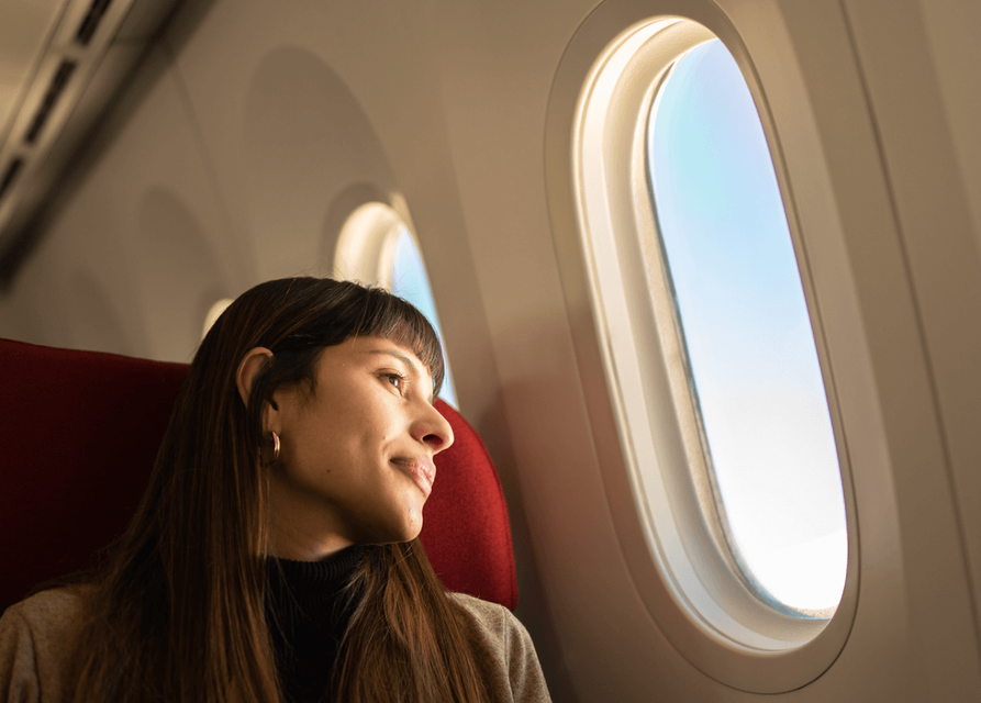 Person looking out of the window of a aeroplane.