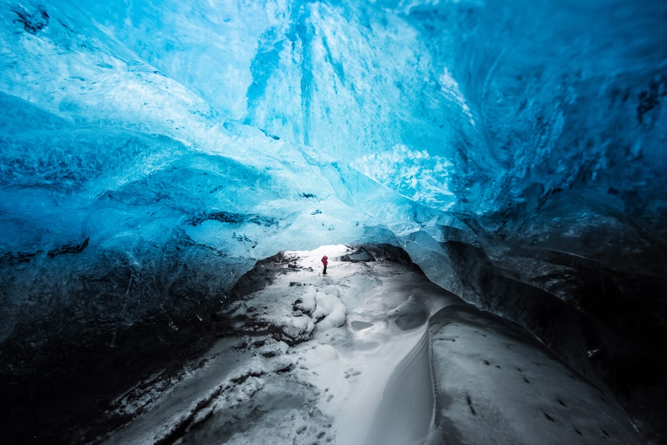 Man traveler enjoying Vatnajokull glacier landmark, Explorer inside ice cave, Skaftafell glacier.