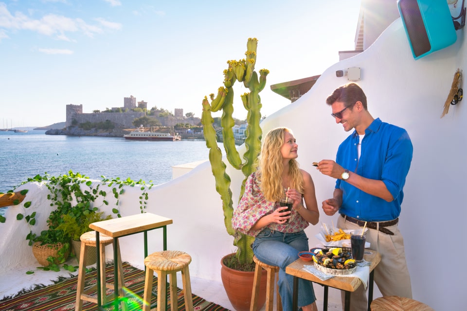 deux personnes prenant un repas devant la côte de Bodrum