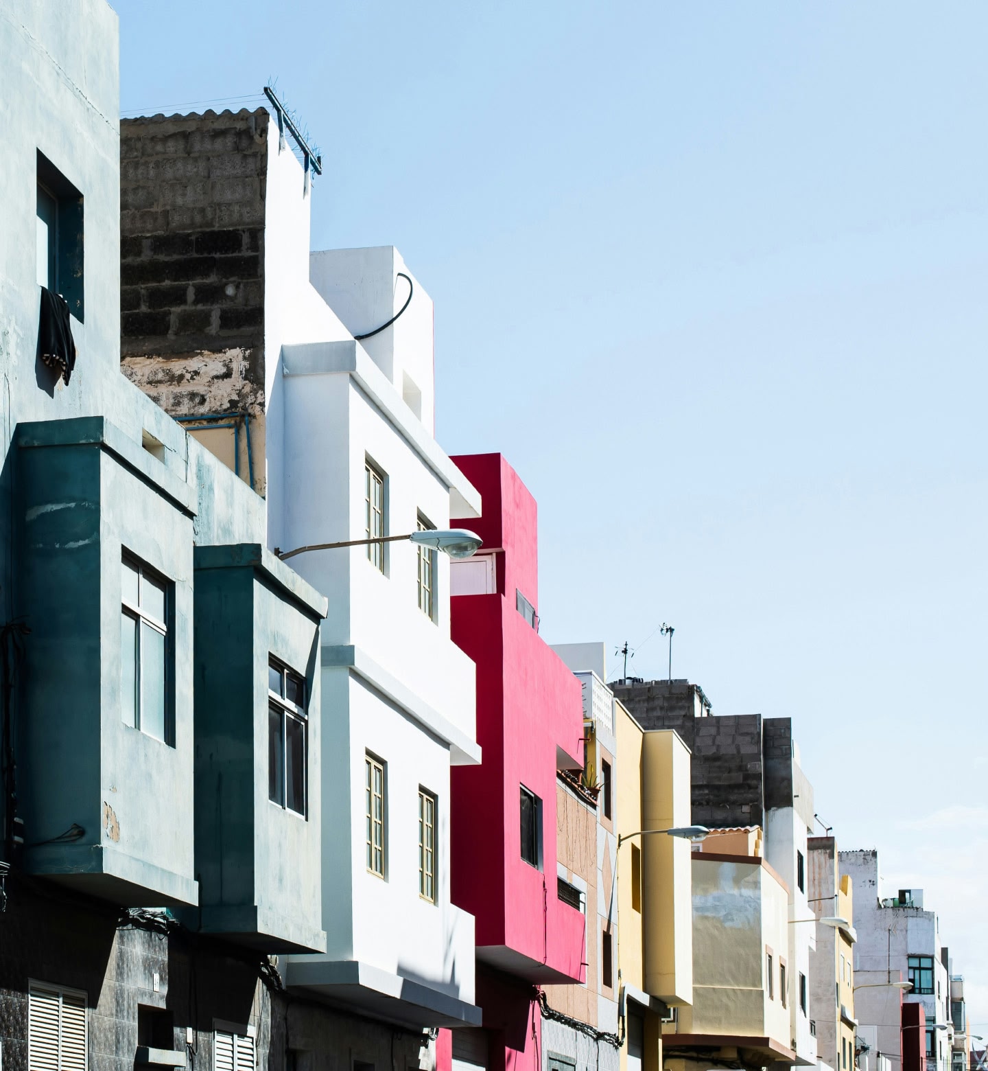 Una schiera di edifici con facciate dai colori vivaci sotto un cielo limpido a Las Palmas, in Spagna.