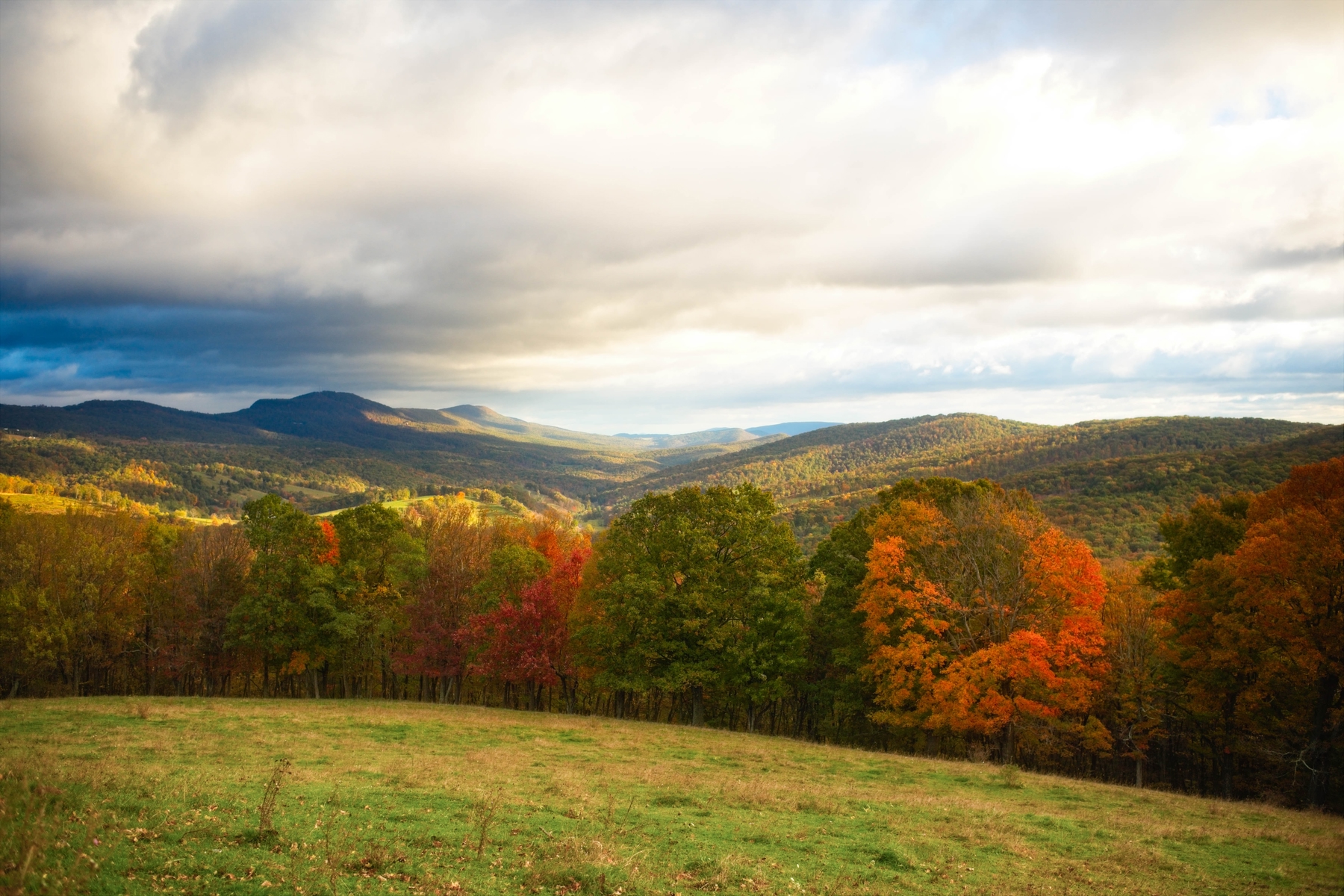 Rolling mountains covered in colorful foliage in small town America