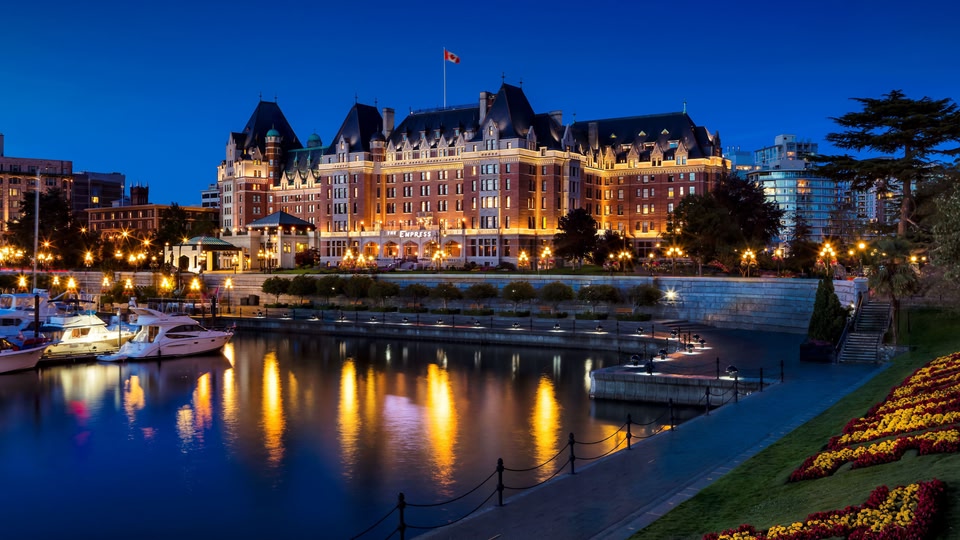 The Empress Hotel in Victoria, British Columbia, Canada, illuminated at night with a waterfront view.