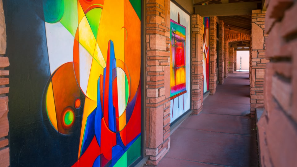 A long corridor with colorful abstract murals on the walls.
